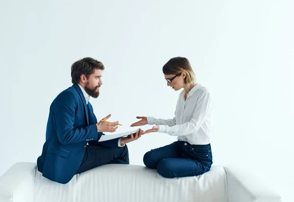 Woman and man are sitting on the couch in suits documents psychology staff