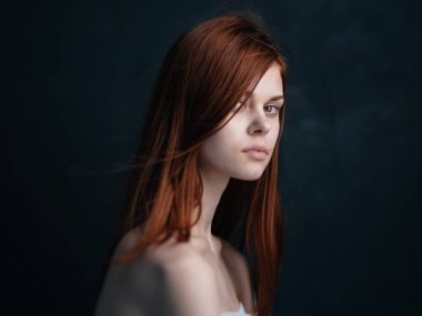 Siyah arka planda kızıl saçlı seksi bir kadın manken.