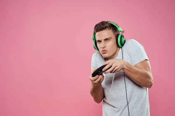 Hombre vistiendo blanco camiseta consola joystick juegos locura tecnología rosa fondo —  Fotos de Stock