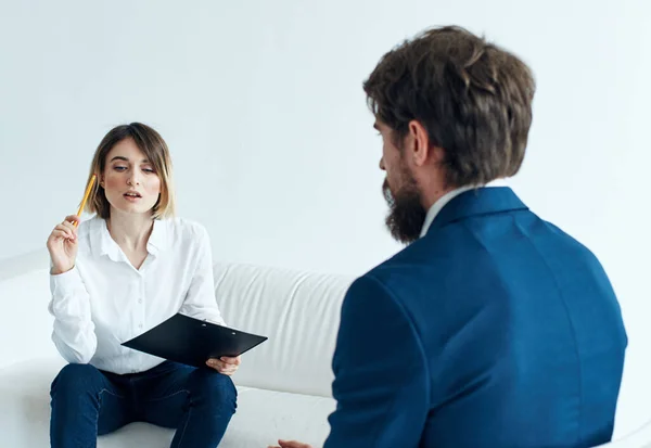 Üzletember klasszikus öltönyben, és egy nő a kanapén dokumentumokkal egy pszichológus kezében. — Stock Fotó