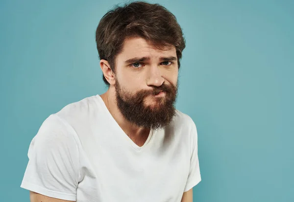 Porträtt av en stilig man på en blå bakgrund med ett beskärt skägg utseende — Stockfoto