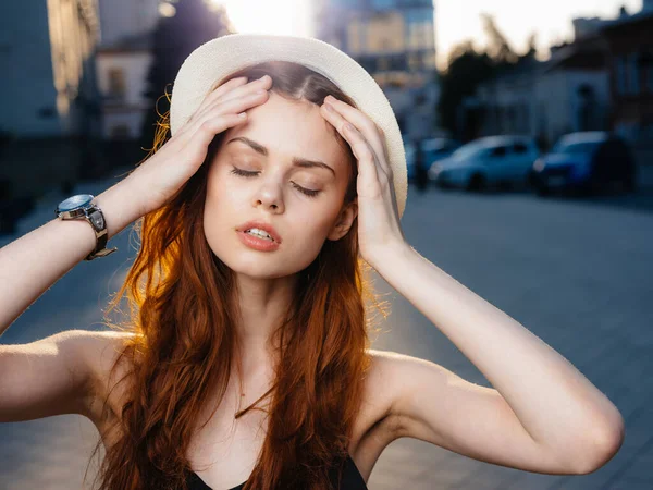 Femme romantique en robe noire et chapeau sont photographiés près de grands bâtiments dans la rue de la ville — Photo