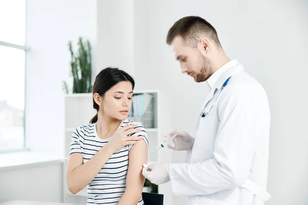 Medico di sesso maschile in camice bianco iniezioni nella spalla di una donna paziente vaccinazioni covid — Foto Stock