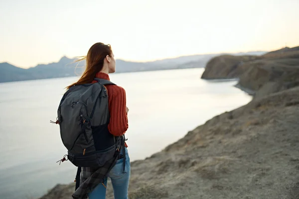 Turismo di viaggio giovane donna con zaino in riva al mare in montagna natura — Foto Stock