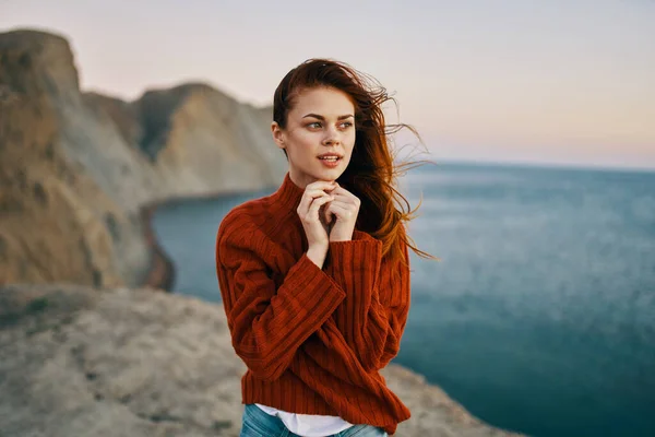 Donna in maglione rosso in montagna vicino al mare modello di turismo di viaggio — Foto Stock