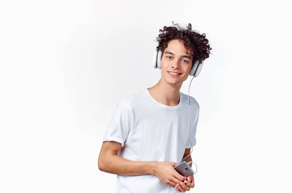Alegre chico en auriculares escucha música emociones luz fondo — Foto de Stock