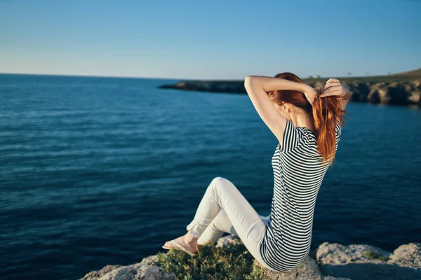 Szczęśliwy podróżnik w t-shirt i spodnie w lecie na kamieniu w pobliżu morza w górach krajobraz — Zdjęcie stockowe