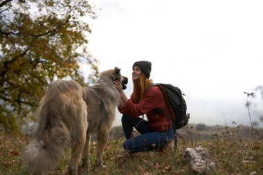 Kadın turist köpek doğa manzarası arkadaşlığı oynuyor.