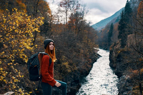 Kvinna vandrare med ryggsäck i bergen höst skog — Stockfoto
