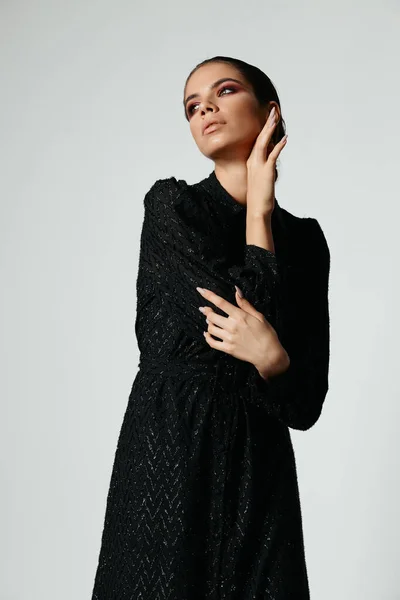 Csinos nő fényes smink gazdaság kéz háború arc fekete ruha divatos stílus — Stock Fotó