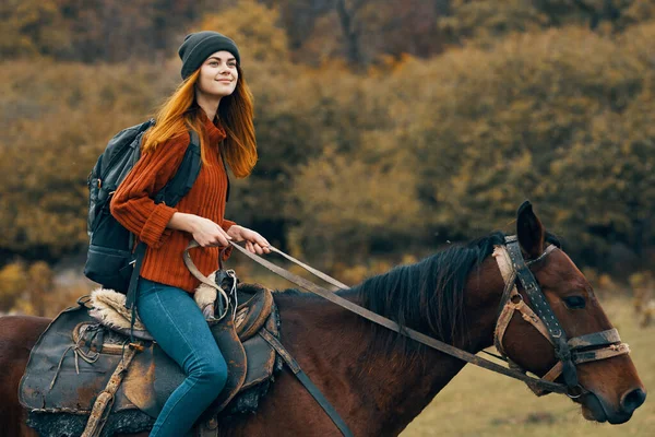 Cheerful woman hiker riding a horse adventure mountains fresh air — Stock Photo, Image