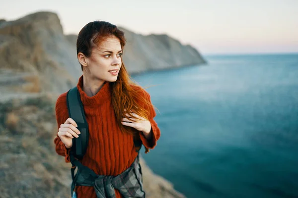 Donna in un maglione con uno zaino in montagna all'aperto vicino al mare vista ritagliata — Foto Stock