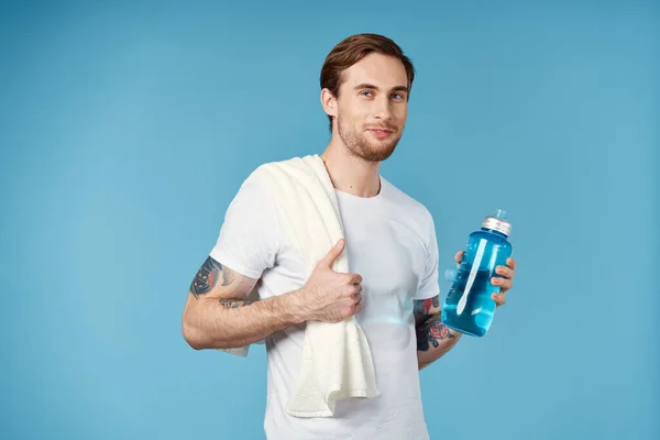 Uomo in bianco t-shirt tatuaggi sulle braccia bottiglia d'acqua fitness lifestyle — Foto Stock