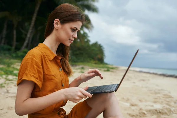 Mulher na praia digitando texto no laptop sentado na areia turismo de viagens freelancer — Fotografia de Stock