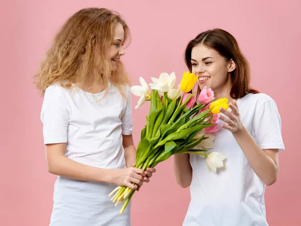 Mama i córka t-shirty bukiet kwiaty prezent różowy tło — Zdjęcie stockowe