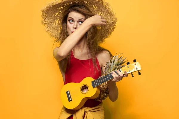 Wesoła kobieta w czerwonym ukulele t-shirt Egzotyczne owoce żółty tło styl życia — Zdjęcie stockowe