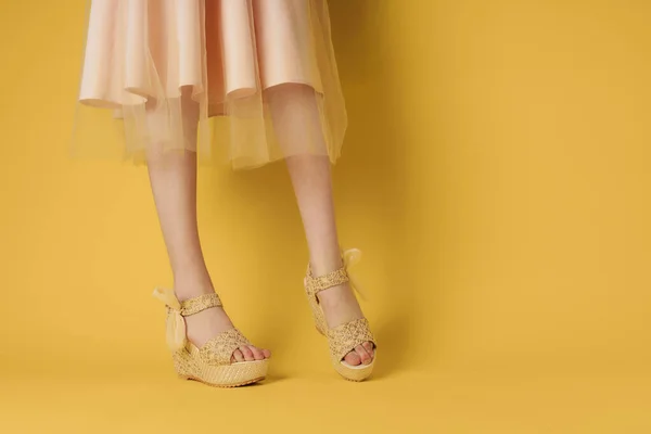 Pies para mujer zapatos de moda ropa fondo amarillo estilo elegante — Foto de Stock