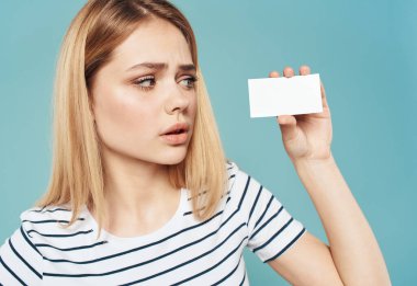 Mavi arka planda kredi kartı olan bir kadın çizgili tişört manzarası çizmiş.