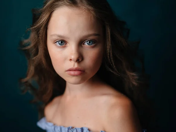 Retrato de una hermosa niña en un vestido de sol sobre un fondo oscuro de cerca — Foto de Stock