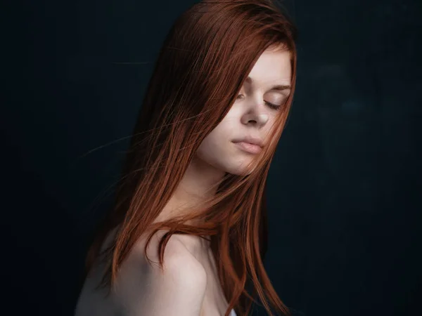 深色背景下红头发漂亮女人的侧视图 — 图库照片