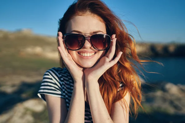 cheerful woman wearing sunglasses mountains outdoors near the sea