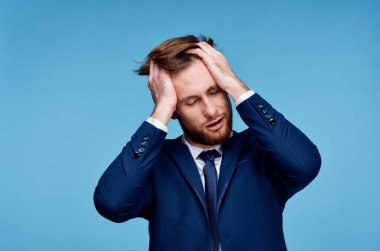 Takım elbiseli bir iş adamı elini duygu yüklü bir şekilde tutuyor.