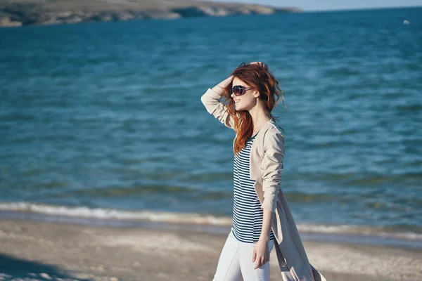 Podróżnik w T-shircie i kurtce na plaży w pobliżu morza w górach — Zdjęcie stockowe