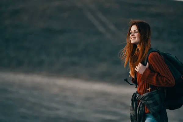 Una mujer en una familia teoría viaja en la naturaleza en las montañas con una mochila sobre sus hombros —  Fotos de Stock