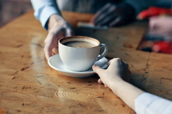 Szef kuchni serwuje klientowi filiżankę kawy ze spodkiem na stole i drinka w restauracji — Zdjęcie stockowe