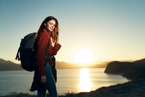 Touristin mit Rucksack auf Naturlandschaft Sonnenuntergang — Stockfoto