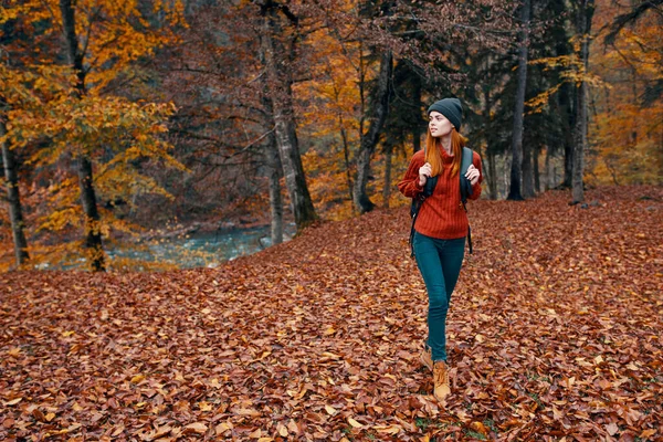 Cestovní ruch a mladá žena s batohem procházky v parku v přírodě krajina vysoké stromy spadl listí řeka — Stock fotografie
