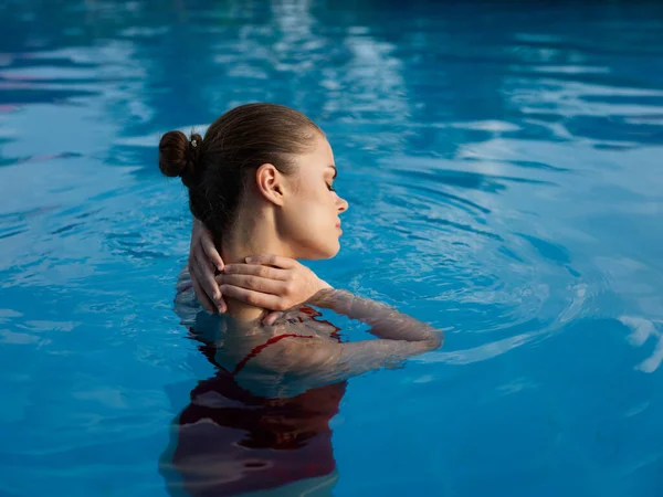 Hermosa mujer con hombros desnudos nadar en el agua transparente de la piscina —  Fotos de Stock