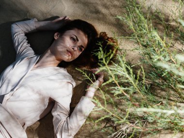 Güzel bir kadın yerde uzanıyor, tropik havayı dinlendiriyor.