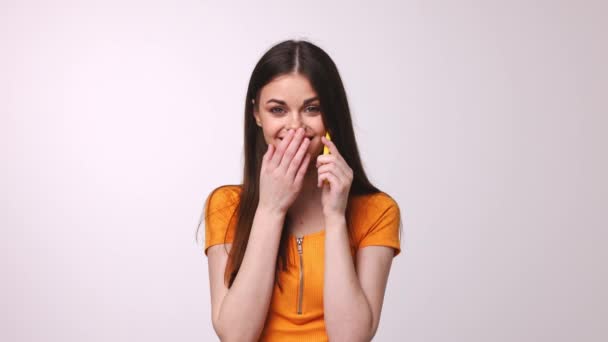 Woman talking on the phone and smiling cute, studio light background — Stock Video