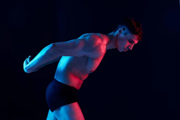 Retrato de un atleta sobre un fondo negro y un modelo de puesta de sol de neón con sombra de noche — Foto de Stock