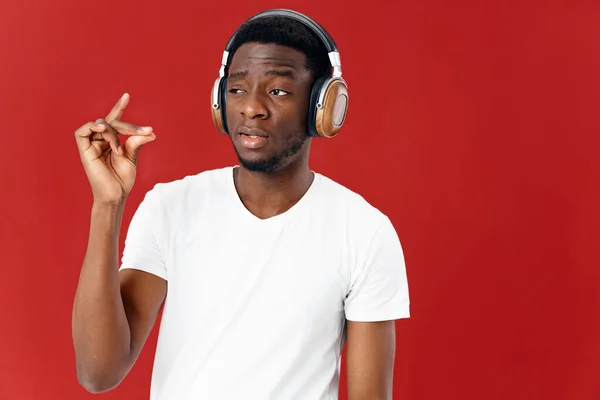 Hombre con auriculares escuchando música en camiseta blanca fondo aislado — Foto de Stock