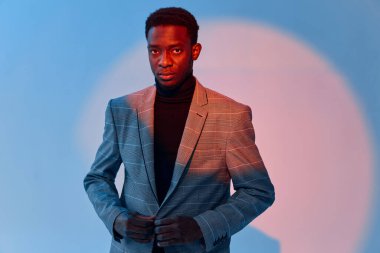 Takım elbiseli Afrikalı görünümlü adam stüdyo özgüveni mavi arka plan