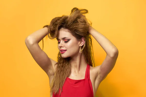 Pretty kobieta faliste włosy czerwony zbiornik top moda styl życia kosmetyki żółte tło — Zdjęcie stockowe