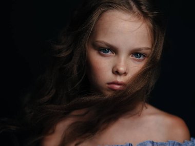 Karanlık arka planda güzel bir kızın portresi. Kendine güvenen bir model.