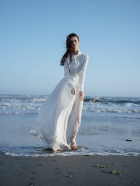 Okyanusun kıyısındaki kumsal modeli kızıl saçlı güzel bir kadın.