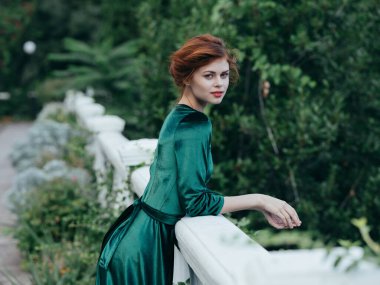 Yeşil elbiseli bir kadının portresi. Temiz hava yeşil yapraklar.