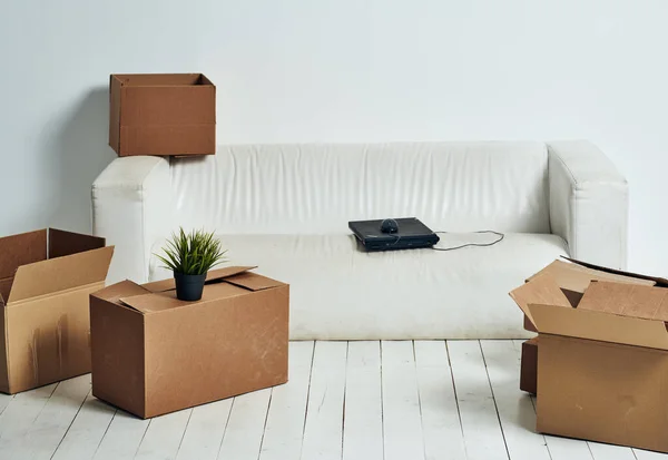 Krabice s věcmi bílá pohovka vybalování kancelář stěhuje — Stock fotografie