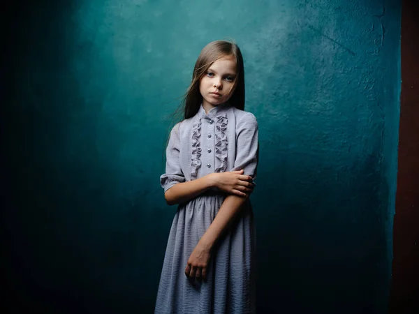 Menina bonita em um vestido de verão cinza com cabelo solto em um fundo turquesa — Fotografia de Stock