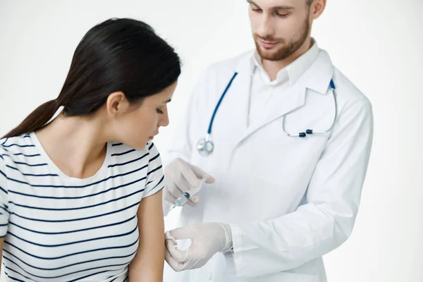 Жіночий пацієнт у медичній масці робить вакцину на ковадлі для здоров'я — стокове фото