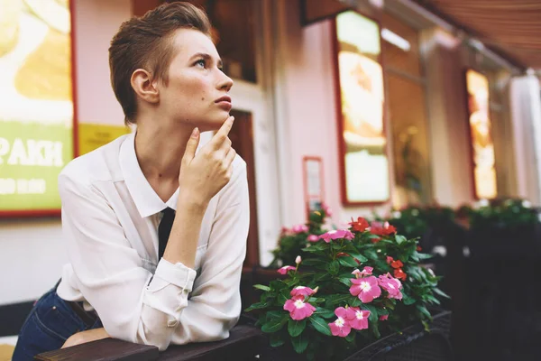 Жінка з коротким волоссям біля будівлі та дизайнерськими квітами модель вулиці — стокове фото