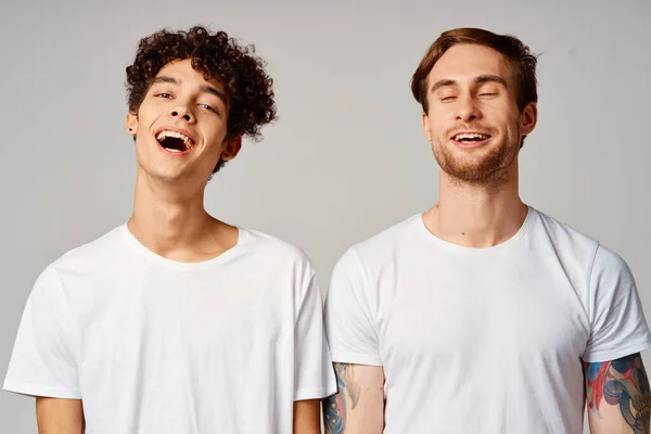 Два друга в белых футболках веселые эмоции изолированный фон — стоковое фото
