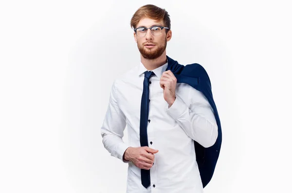 Homem de negócios em uma camisa e gravata segura uma jaqueta em seu ombro em um fundo leve — Fotografia de Stock
