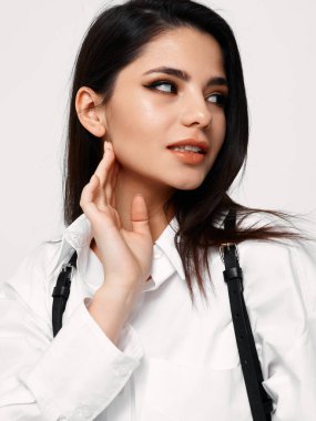 Akşam makyajlı seksi esmer. Yüzüne eliyle dokun ve yana bak.