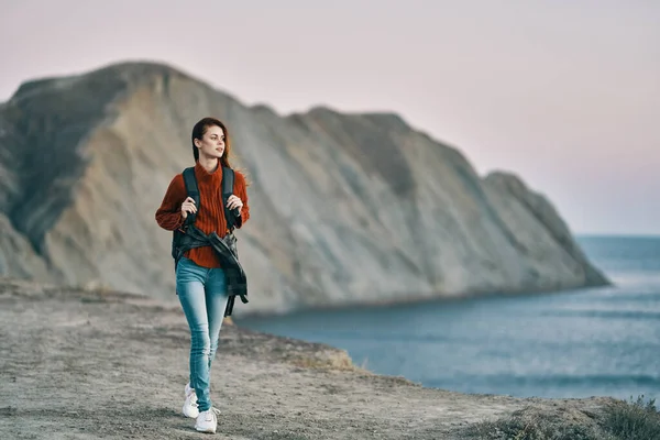 Woman Sweater Jeans Sneakers Seashore Mountains Background High Quality Photo — Stock Photo, Image