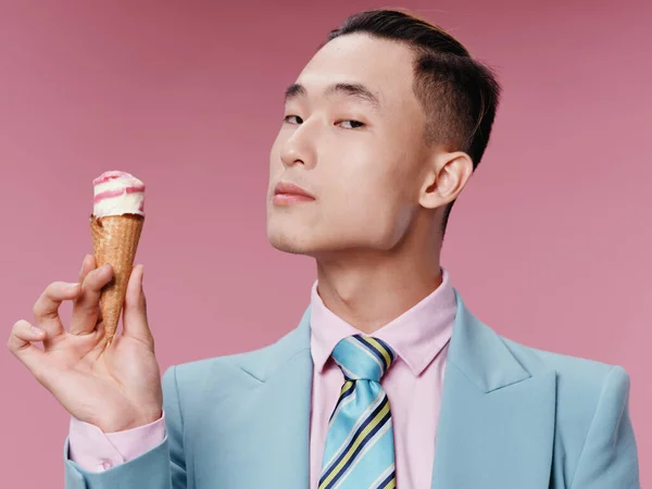 Asian guy in classic suit hairstyle ice cream pink background model portrait close-up